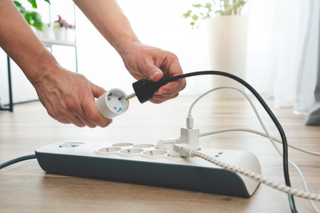 Man plugging the smart power plug. Electrical plug in outlet socket at home.の写真素材