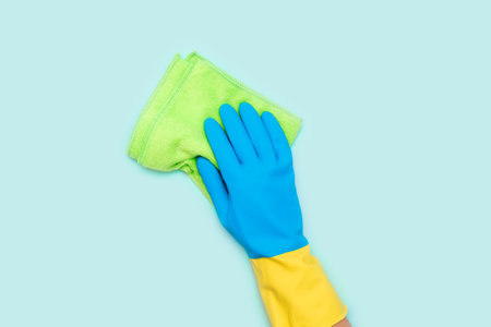 Cleaning services, hand with a yellow sponge in blue gloveの写真素材