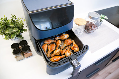 Air fryer machine in the kitchen. Baked chicken legs.の写真素材