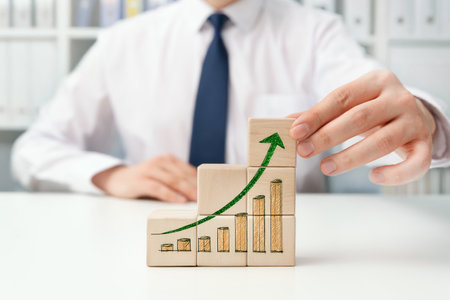 Growing business concept with wooden blocks. Businessman in officeの写真素材