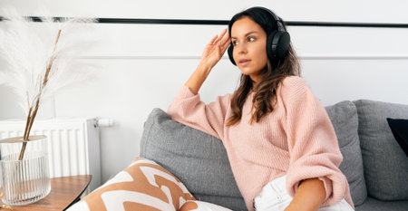 Woman listening music with headphones, relaxing at homeの写真素材