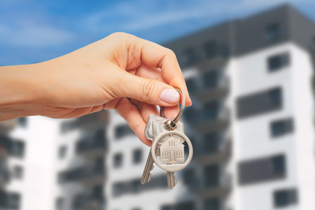 Woman holding key to new home. Loan or buy apartment conceptの写真素材