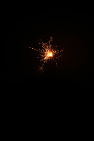 Yellow sparks fly on a black background, layered with grain, noise, and glowing effects to give a gritty, cinematic feel full of motion, contrast, and intense visual energy.の写真素材