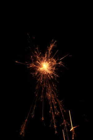 Yellow sparks fly on a black background, layered with grain, noise, and glowing effects to give a gritty, cinematic feel full of motion, contrast, and intense visual energy.の写真素材