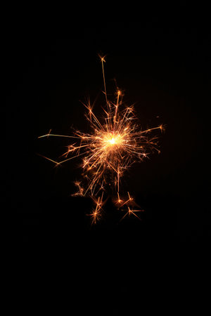 Yellow sparks fly on a black background, layered with grain, noise, and glowing effects to give a gritty, cinematic feel full of motion, contrast, and intense visual energy.の写真素材