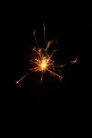 Yellow sparks fly on a black background, layered with grain, noise, and glowing effects to give a gritty, cinematic feel full of motion, contrast, and intense visual energy.の写真素材