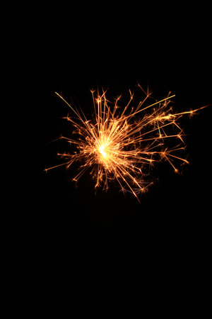 Yellow sparks fly on a black background, layered with grain, noise, and glowing effects to give a gritty, cinematic feel full of motion, contrast, and intense visual energy.の写真素材