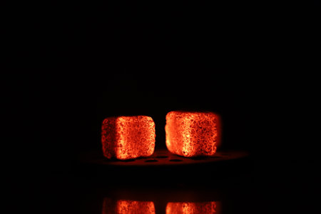 Glowing coals with glitch style lighting, enriched by noise, effect and grain details, create a mystical atmosphere in the dark. A vivid sense of heat and depth surrounds the imageの写真素材