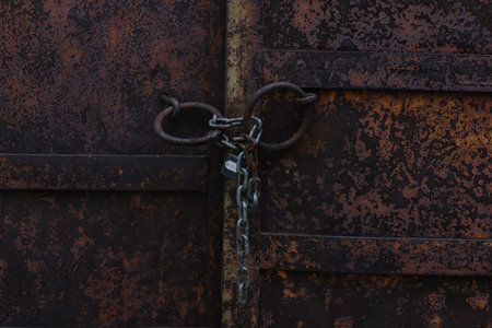 Rusty metal door with chain and padlock, closeup of photoの写真素材