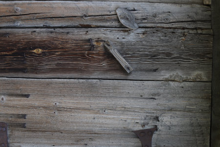 Old wooden wall with an ax and a nail, close-upの写真素材