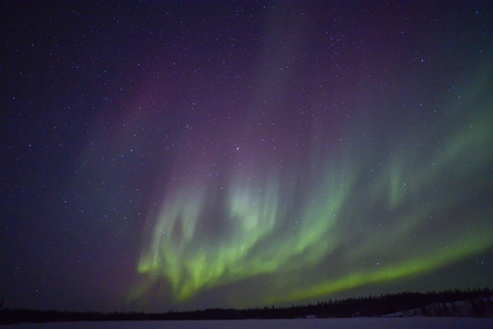 Northern lights aurora borealis in the night sky over beautiful frozen lake landscapeの写真素材