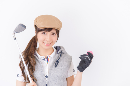 Young woman golf player smiling isolated on white background.の写真素材