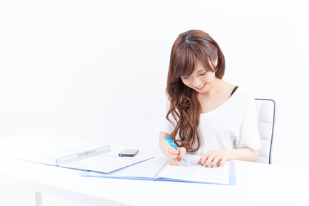 Young Japanese woman writing on white backgroundの写真素材