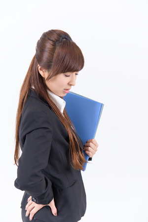 Young Japanese business woman has a bad lower back on white backgroundの写真素材