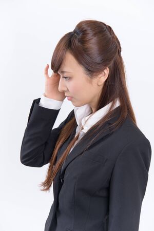 Japanese young woman with a headache holding head, isolated on white backgroundの写真素材