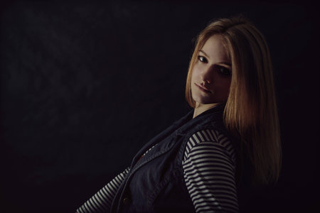 portrait of beautiful thoughtful girl close up in the darkの写真素材