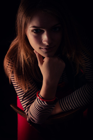 portrait of beautiful thoughtful girl close up in the darkの写真素材