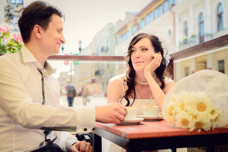 unusual loving wedding couple in cafe drinks a cappuccinoの写真素材