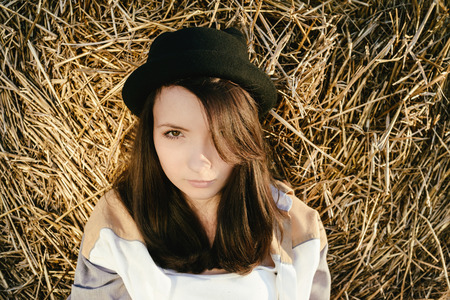 portrait of beautiful girl hipster against  hay bale in fallの写真素材
