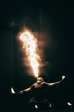 active European guy carries out tricks for fire show at nightの写真素材