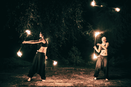 active European girls carries out tricks for fire show at nightの写真素材