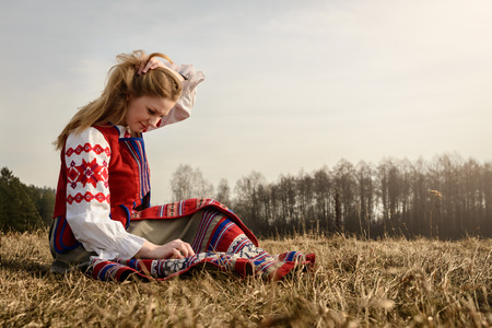 young woman in a Slavic Belarusian national original suit outdoorsの写真素材