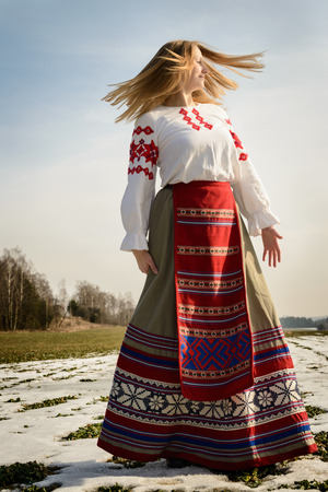 young woman in a Slavic Belarusian national original suit outdoorsの写真素材