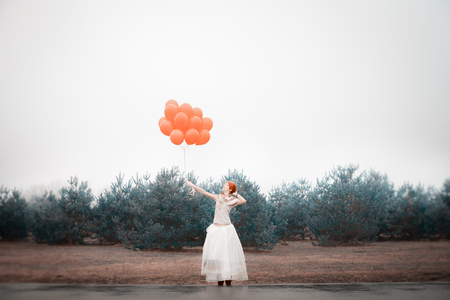 unusual woman with balloons as a concept outdoorsの写真素材