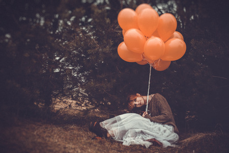 unusual woman with balloons as a concept outdoorsの写真素材