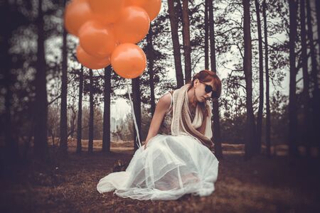 unusual woman with balloons as a concept outdoorsの写真素材