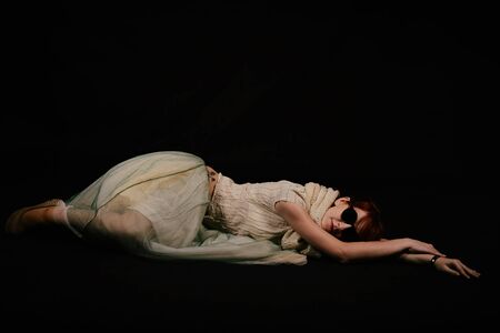 unusual woman in studio with red hair and sunglassesの写真素材