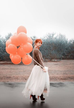 unusual woman with balloons as a concept outdoorsの写真素材