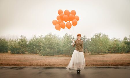 unusual woman with balloons as a concept outdoorsの写真素材