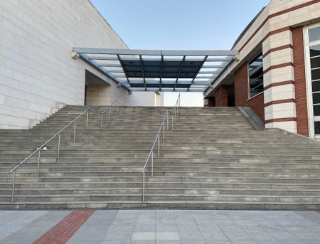 Concrete stone walls and stairs with steel rails, modern architecture building with red bricks,...