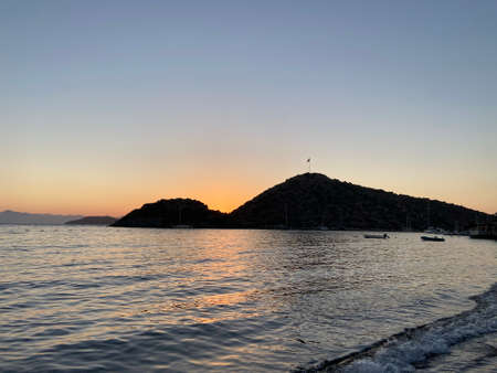 Beautiful sea view at sunset, colorful at dawn, reflections on the sea, sun shades, lights and islands on the aegean sea.の写真素材