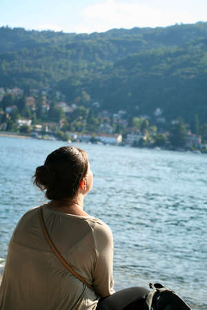 Young woman traveling, meditating in the city outdoors, looking at the view, watching, relaxing, looking for new beginnings, trying to feel better, learning, full concentration, no distractions.の写真素材