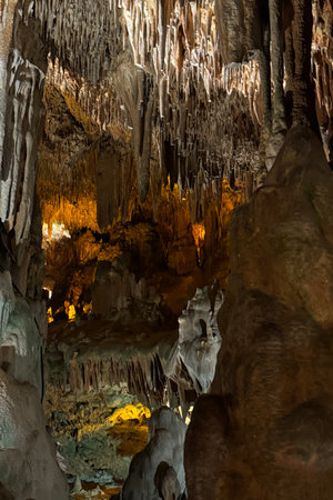Cave wall with light, interior of the beautiful cave, abstract background and texture, stalactites and stalagmites, underground, natural water shaped wallsの写真素材