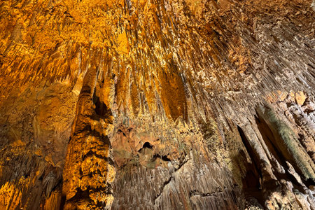 Cave wall with light, interior of the beautiful cave, abstract background and texture, stalactites and stalagmites, underground, natural water shaped wallsの写真素材