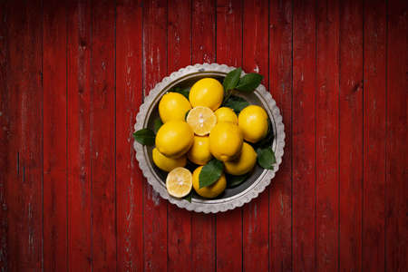 Fresh lemons on red rustic background. Top view.の写真素材