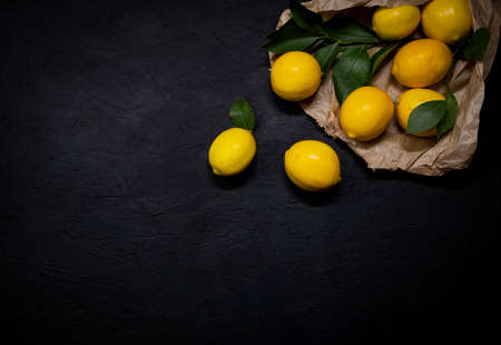 Fresh lemons on dark stone background. Top view.の写真素材