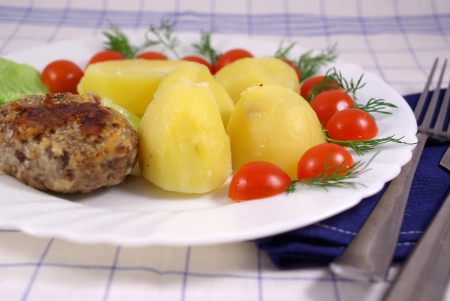 Boiled potatoes with cutlet and vegetablesの写真素材