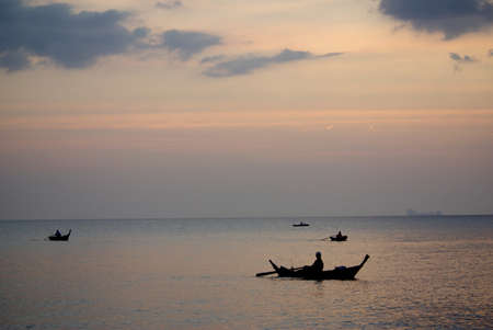 KOH LANTA, THAILAND - January, 2014: Fisherman in boat at sunset on the Andaman Sea, Thailandのeditorial素材