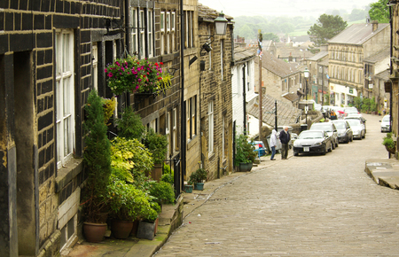 HAWORTH, ENGLAND - June, 2013: Old narrow street with tourists in the village of Haworth in summer dayのeditorial素材