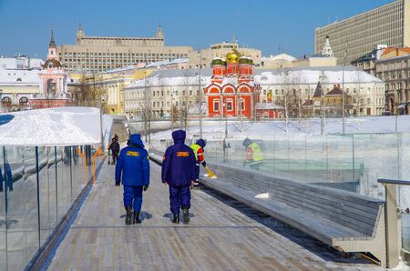 MOSCOW, RUSSIA -  FEBRUARY 2018: The janitor sweeping the benches on the Floating Bridge in Park  Zaryadyeのeditorial素材