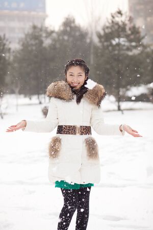 The Chinese girl playing in the snowの写真素材