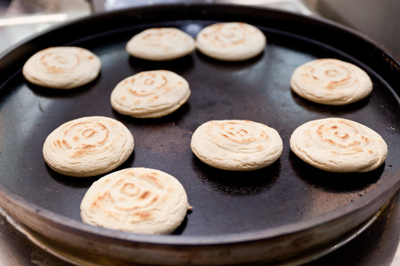 Pork belly caramelised and braised in soy sauce with star anise, cinnamon and chilies inside a steamed bun.の写真素材
