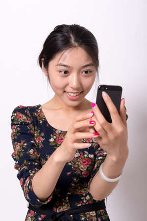 Beautiful girl playing mobile phoneの写真素材