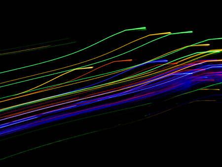 Abstract light paint art with colorful lights backdrop high speed motion in dark and shadow. Include Red Blue Green Gold Orange long lines pattern. This drawing shape loop photo is luxury neon design.の写真素材