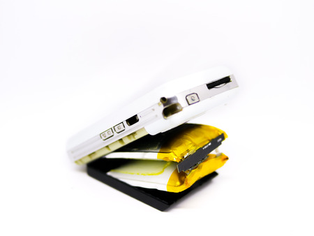 Isolated swollen battery with a phone on white background.の写真素材