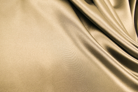 Smooth elegant gold beige color silk or satin luxury cloth fabric texture, abstract background design.の写真素材